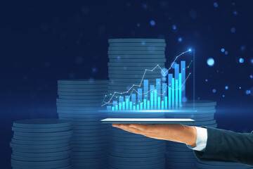 Wall Mural - Close up of businessman hand holding tablet with glowing growing business chart on blurry bokeh background. Financial growth and success concept.