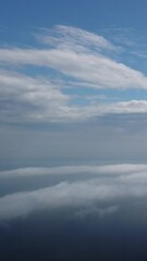 Wall Mural - aerial view. blue sky sun and fog over calm sea. the drone flies over foggy and fluffy clouds. abstr