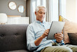 © Penn/peopleimages.com - Senior man, tablet and retirement in home for typing email, communication and reading online news. Elderly person, technology and relax on sofa in lounge for bills payment, video and reading ebook