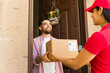 © AntonioDiaz - Customer joyfully accepting a delivery from a female courier at his doorstep