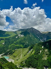 Panoramic view of the green Caucasus mountains in sunny weather and cloudy sky