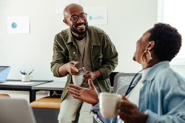 Co-workers bonding and laughing together in modern office setting