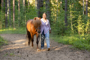 Wall Mural - Woman with Icelandic horse on path middle of the forest