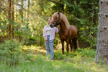 Wall Mural - Woman with Icenlandic horse in forest with sunset on behind