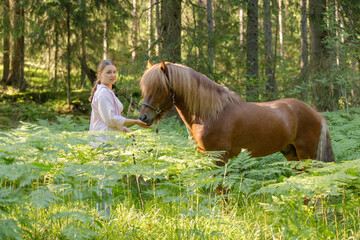 Wall Mural - Woman with Icelandic horse middle of ferns during the sunset