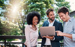 © peopleimages.com - Business people, laptop and collaboration for research outdoor for website review and reading project feedback. Marketing team, employees and laughing for b2b networking and planning ideas at cafe