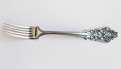 Ornate silver fork with detailed handle, placed on a plain white background, showcasing intricate craftsmanship