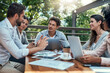 © BestLens/peopleimages.com - Cafe, business people and meeting with team for discussion, review and finance feedback with laptop. Outdoor, men and women for accounting firm with report, planning and ideas with employees