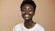 © xuxu - Studio shot of an African American black girl, 20-25 years old, with short hair, wearing a white t-shirt, smiling, against a beige background