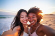 © ALLAI - Smiling Asian and African American women taking a selfie on a beach at sunset, capturing a joyful moment