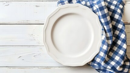 Canvas Print - Empty white plate on wooden white table with checkered blue linen napkin. Flat lay, top view, copy space