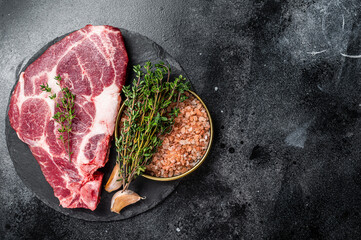 Wall Mural - Pork loin steak, raw neck meat with thyme and salt. Black background. Top view. Copy space