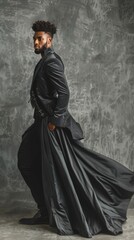 A fashion model in a flowing black gown poses dramatically