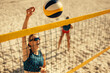 © Jacob Lund - Female athlete engaging in an intense volleyball game on a sunny beach