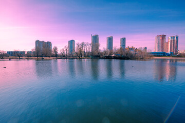 Canvas Print - Kyiv in the morning. Left bank of the Dnieper River. Beautiful reflection of buildings in the lake