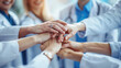 © Robert Kneschke - Group of dedicated healthcare professionals showcasing teamwork by stacking hands together