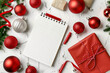 © Iqra - Wish list for Christmas and New Year. New Year plan and red Holiday decorations, ruled notebook and wish list on white table. View from above. Flat lay. Gift expense planning