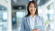 © ChubbyCat - Cheerful businesswoman using innovative work tools with a digital tablet.