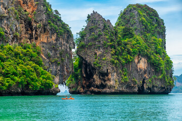 Wall Mural - Rocky island on Phra Nang beach, Railay Bay, Krabi, Thailand. People kayaking between tropical cliffs. Summer vacation and holiday background