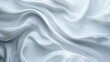 © Олег Фадеев - Close-up of a white, satin-like fabric with a smooth, glossy texture, displaying a series of fluid, undulating folds and creases that create a sense of softness and depth