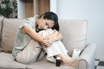 Sad and depressed young female sitting on the sofa, sad mood, feel tired, lonely and unhappy concept.