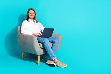 Wall Mural - Full length photo of cheerful positive guy dressed white shirt working modern device emtpy space isolated turquoise color background