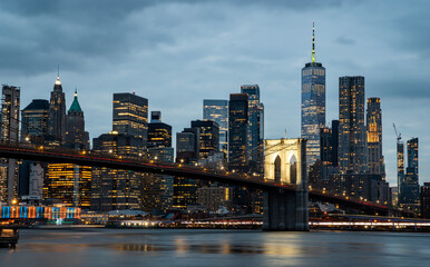 manhattan skyline at night with brooklyn bridge lights