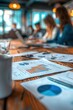 © Sunshine - Close-up of financial charts and graphs on a wooden table during a business meeting in a modern office setting.