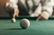 © Imagination  World - Focused shot of a cue ball on a billiard table with a player aiming in the background, highlighting the precision and skill in the game of pool.