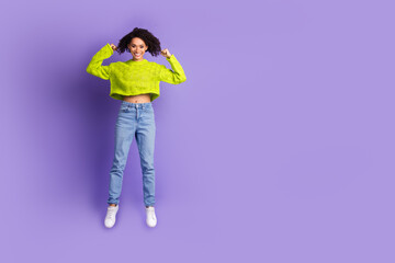 Wall Mural - Full body photo of attractive young woman jump show biceps dressed stylish green clothes isolated on violet color background