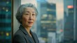 © Summit Art Creations - The picture of the senior asian female financial executive standing near the window of the office inside building, the financial job require skills like finance knowledge and planning budget. AIG43.