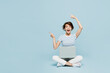 © ViDi Studio - Full body shocked young IT woman wears striped t-shirt casual clothes sitting hold use work on laptop pc computer point index finger aside on area isolated on plain blue background. Lifestyle concept.
