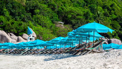 Wall Mural - Beach chairs on the white sand beach and umbrella, Wooden deck chairs on sandy beach near sea with umbrella beach, Koh nangyuan, Surat Thani, Thailand.