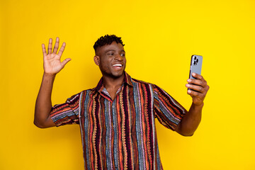 Wall Mural - Photo of nice young man phone selfie arm wave wear shirt isolated on yellow color background