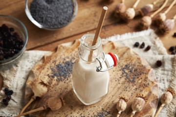 Wall Mural - Homemade vegan poppy seed milk in a glass bottle with ecological paper straw. Zero waste.