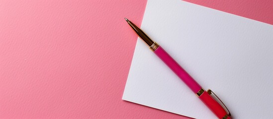 Fototapete - Pink background showcasing a white sheet of paper with a pen in the frame, ideal for adding text, featuring copy space image.