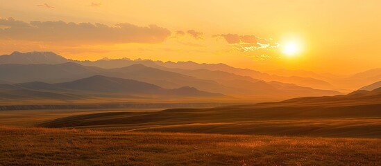 Wall Mural - Gorgeous Mongolian Altai sunset over blue ridge mountains with orange sky, perfect for a copy space image.