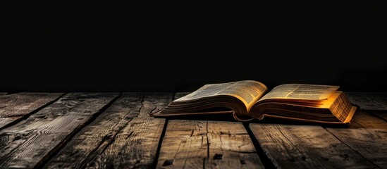Poster - A book on a wooden table with a black background, allowing for copy space in the image.