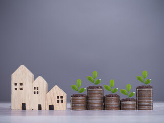 Poster - Miniature house and plants growing up on stack of coins. The concept of saving money for house, Property investment, House mortgage, Real estate.