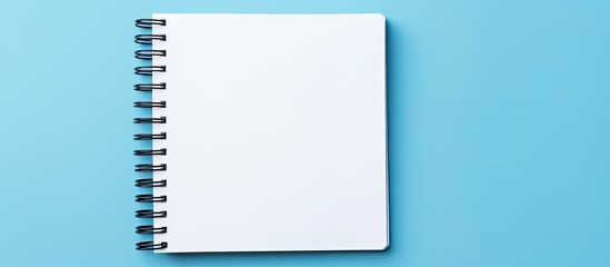 Fototapete - Minimalist flat lay style top view of an open spiral notebook on a stylish classic blue background, providing a place for text in this copy space image.
