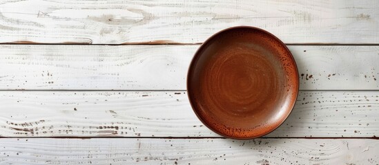 Aufkleber - Empty brown plate on white wooden table with ample copy space image.