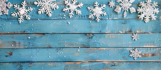 Poster - Vintage blue wooden boards adorned with Christmas snowflake decorations create a charming holiday postcard frame, perfect for displaying your text and design against a copy space image.