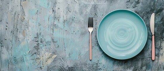 Aufkleber - A colored ceramic plate placed on a concrete background, ready for a meal with cutlery, having a blank area for an image.
