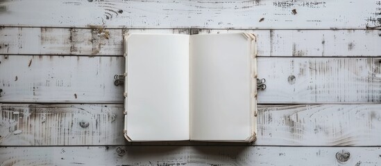 Fototapete - White wooden background with an open notebook that has clips for papers, providing space for copying images.
