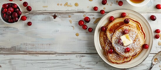 Sticker - A flat lay of cereal pancakes with cranberries and butter on a white wooden table, providing room for a text message in the copy space image.