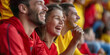 © MNStudio - Excited sports fans wearing red and yellow clothes celebrating the victory of their team. People chanting and cheering for their soccer team. Family watching football match.