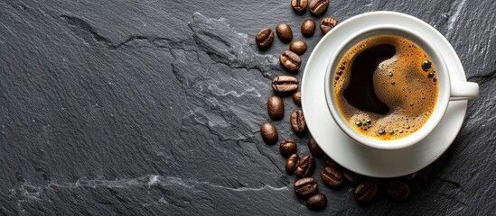 Wall Mural - Top view of a white cup with hot coffee on a stone table board background featuring a copy space image