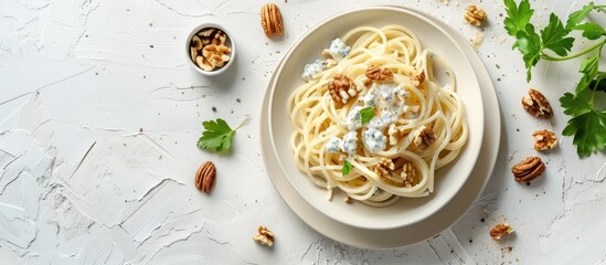 Fototapete - Italian homemade spaghetti in creamy blue cheese sauce with walnuts presented as a delicious vegetarian option Top view on a white background with available copy space image