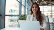© AlfaSmart - A happy businesswoman works on her laptop in a modern office