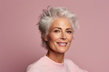 Poster - Portrait of smiling senior woman with short white hair on pink background